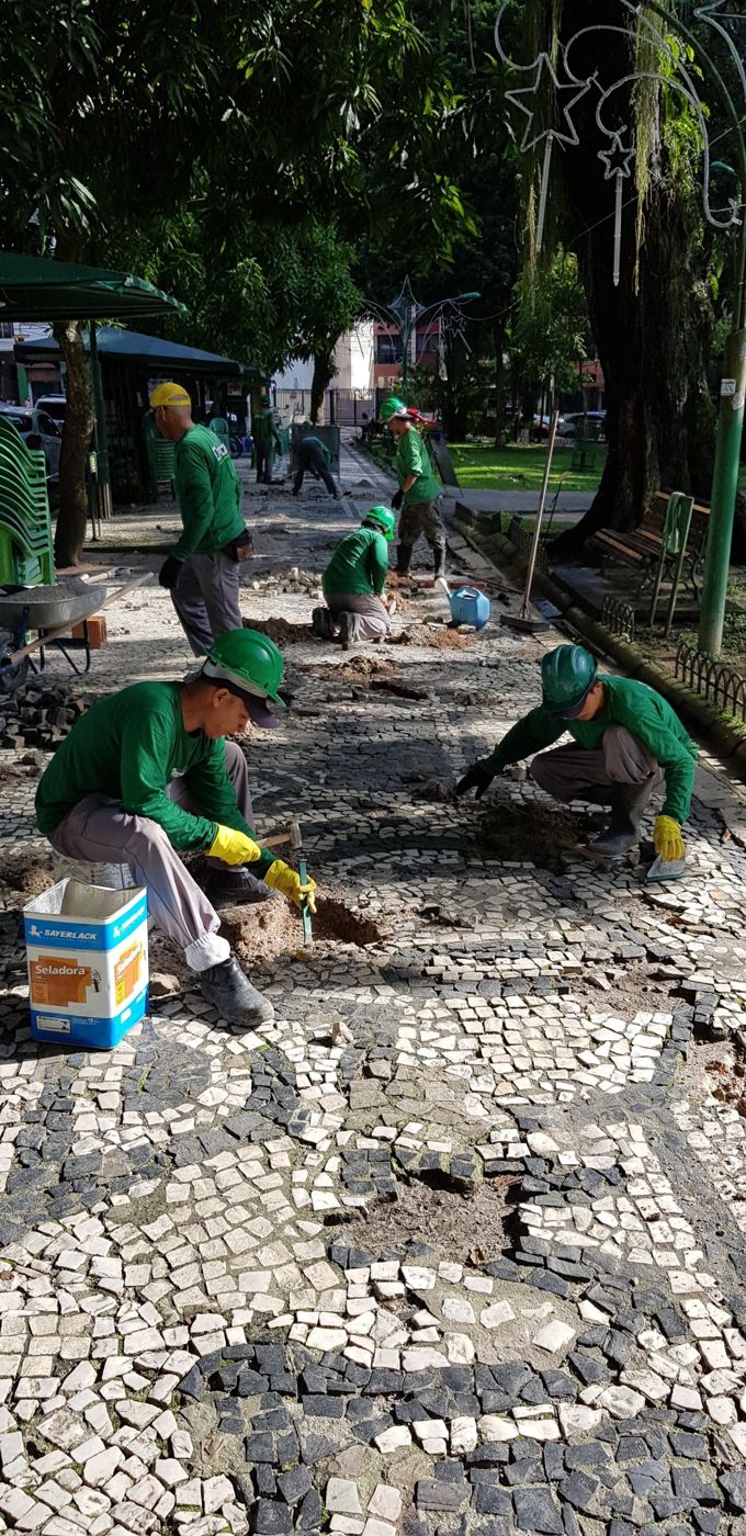 Equipe recuperando a calçada em pedra portuguesa da Praça Batista Campos