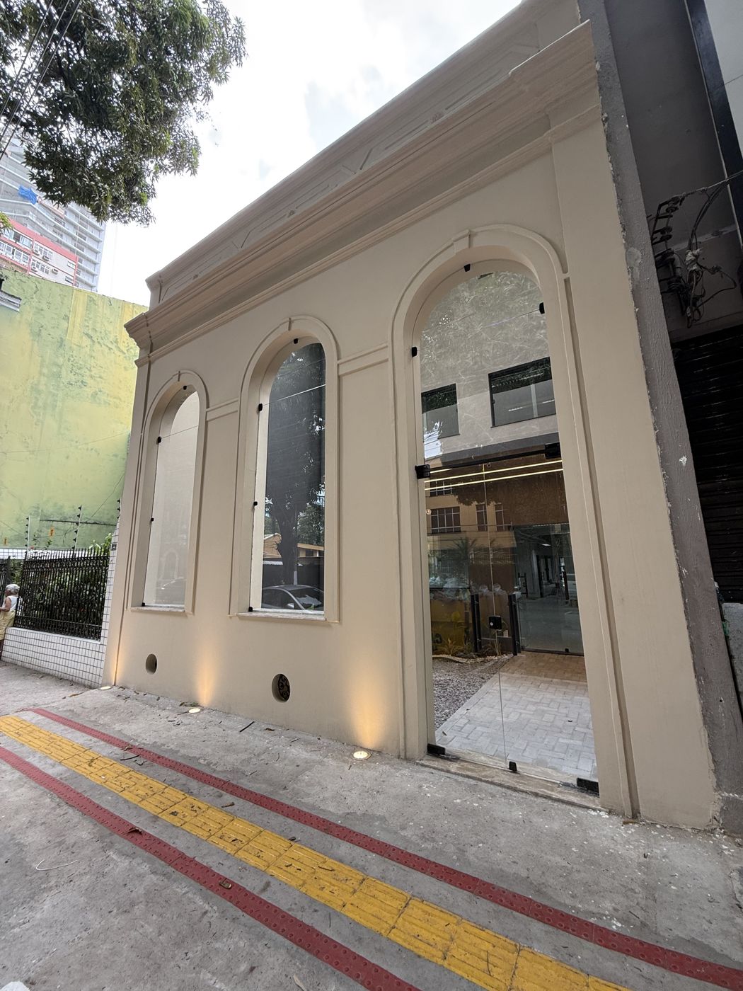 Fachada histórica revitalizada com arcos e portas de vidro
