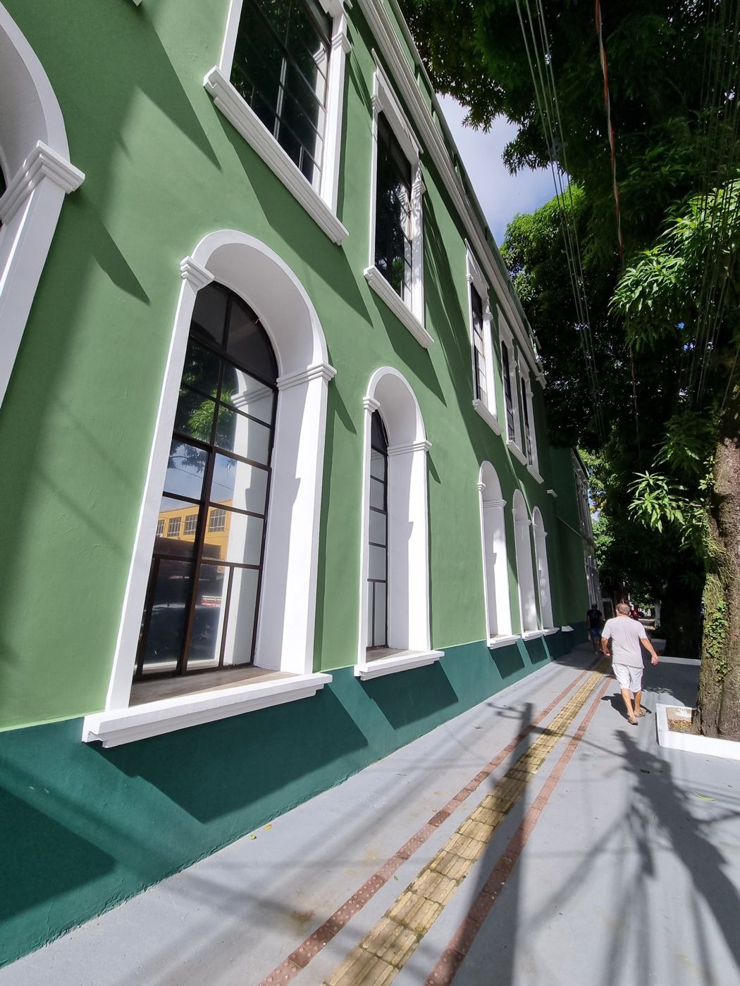 Fachada histórica da PGE recuperada, com calçada e piso tátil